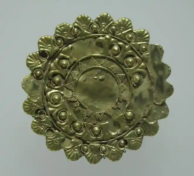 Gold circular plaque with the sun at the center and geometrically derived crosses around
